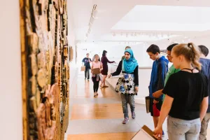 Visitors viewing artworks in a museum gallery.