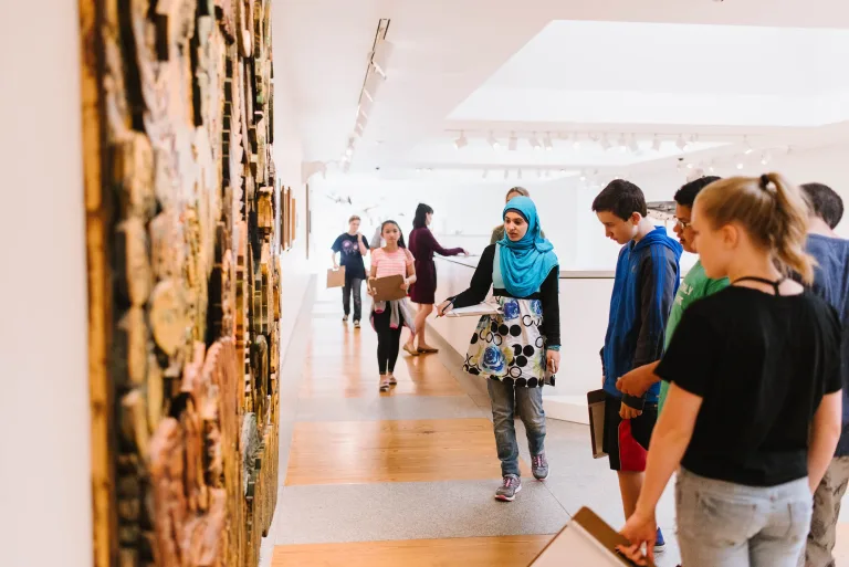Visitors viewing artworks in a museum gallery.